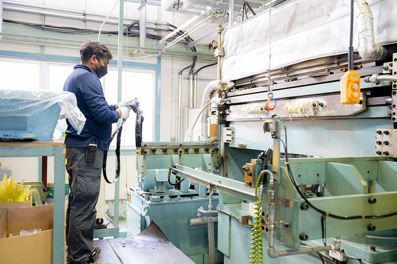 工場内でゴムを金型に入れて成形している工程